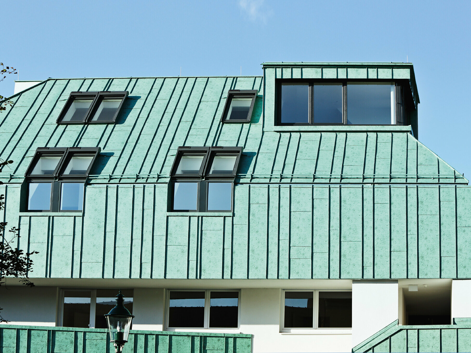 Riešenie strechy a fasády so systémom PREFALZ vo farbe patina zelená od spoločnosti PREFA s rôznymi šírkami pásov