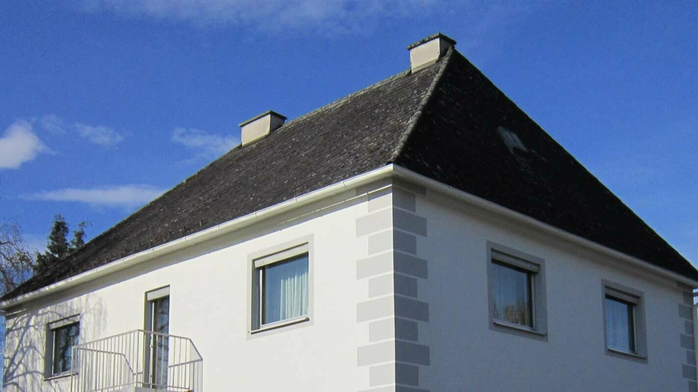 Dom v Rakúsku pred rekonštrukciou  valbovej strechy  s použitím krytiny Prefalz a PREFA falcovaných škridiel