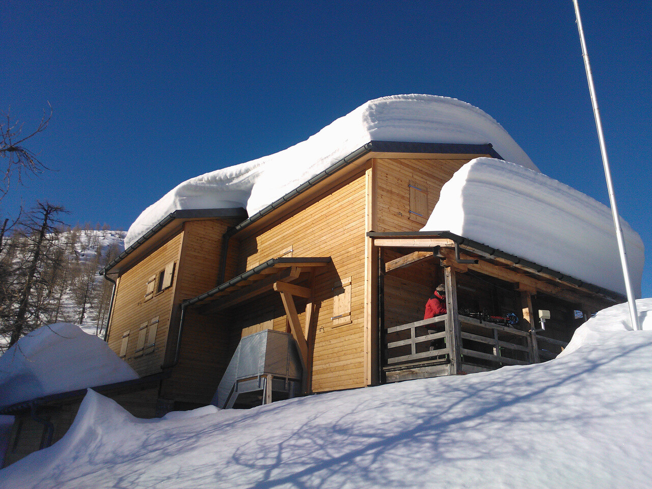 Chata Capanna Buffalora s viacerými centimetrami snehu na streche. 