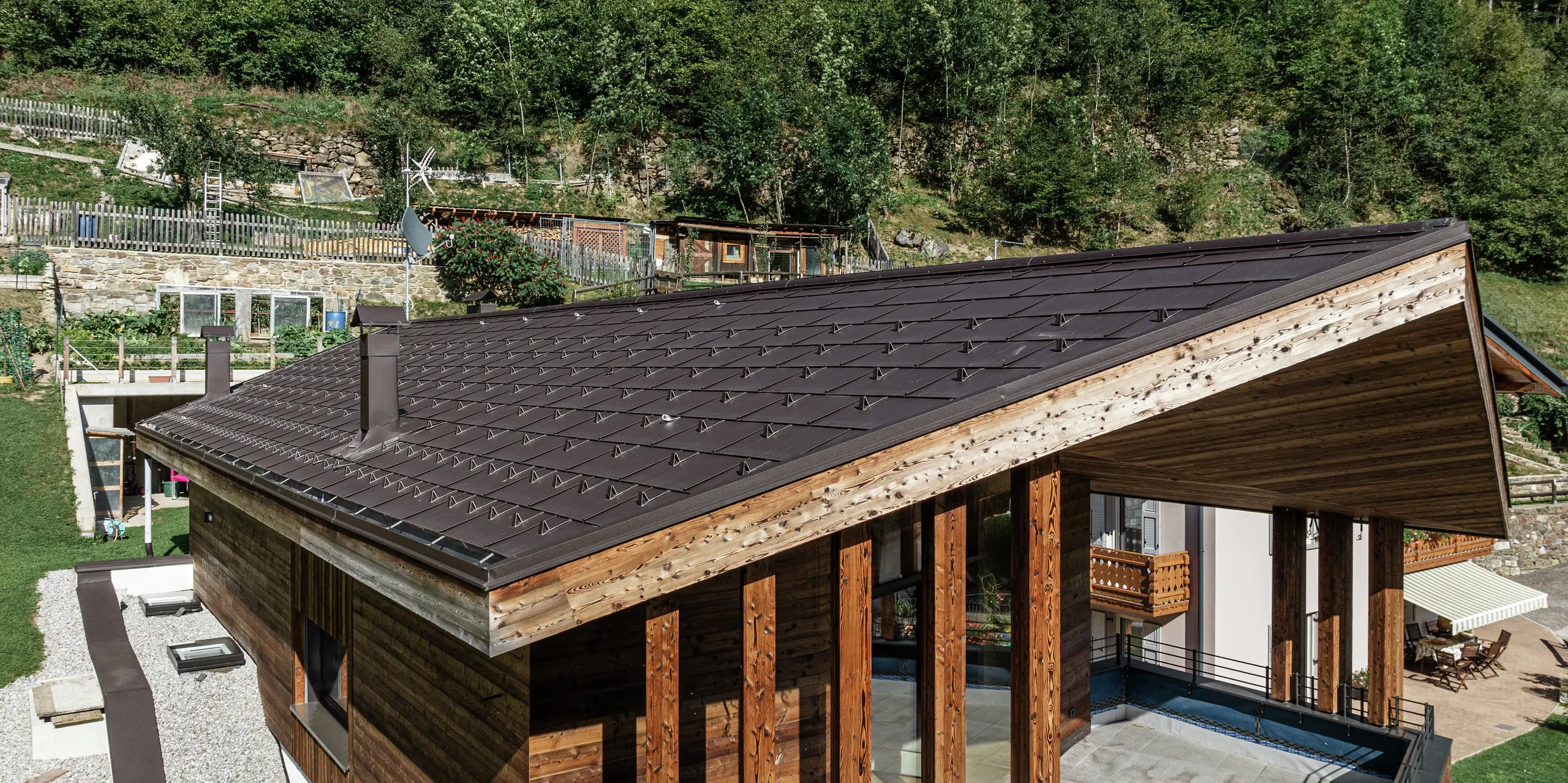 Moderná horská chata v Cogolo v údolí Val di Sol s odolnou hliníkovou strechou PREFA. Strešný panel PREFA R.16 v hnedej farbe P.10 harmonicky zapadá do drevenej architektúry a poskytuje optimálnu ochranu pred extrémnymi poveternostnými podmienkami. Odolný, bezúdržbový a ideálny do alpských oblastí - dokonalá kombinácia dizajnu a funkčnosti.