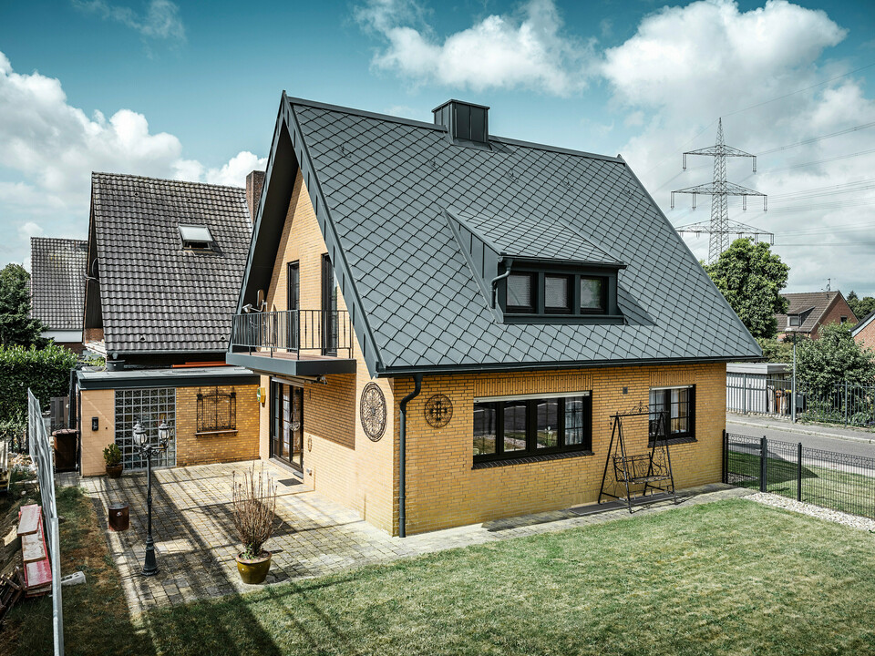 PREFA strešná šablóna 29 × 29, PREFALZ, žľab a dažďový zvod vo farbe P.10 antracitová zdobia rodinný dom v Tönisvorste.
