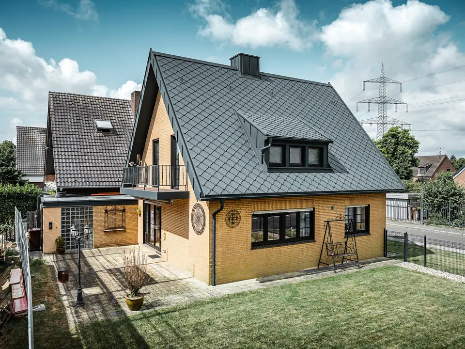 PREFA strešná šablóna 29 × 29, PREFALZ, žľab a dažďový zvod vo farbe P.10 antracitová zdobia rodinný dom v Tönisvorste.