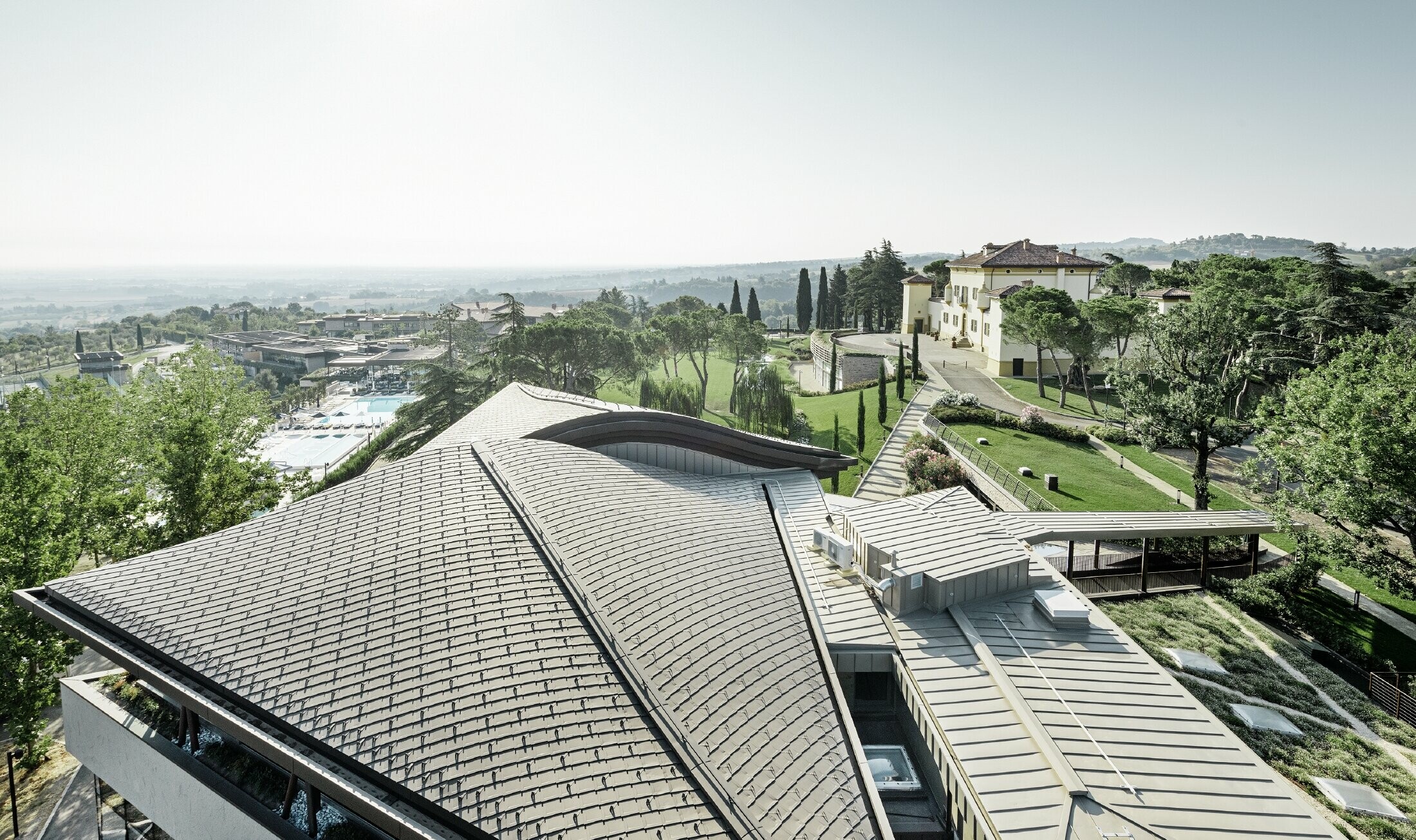 Palazzo Golfresorts Varignana s rozsiahlou hliníkovou strechou PREFA v hnedej farbe