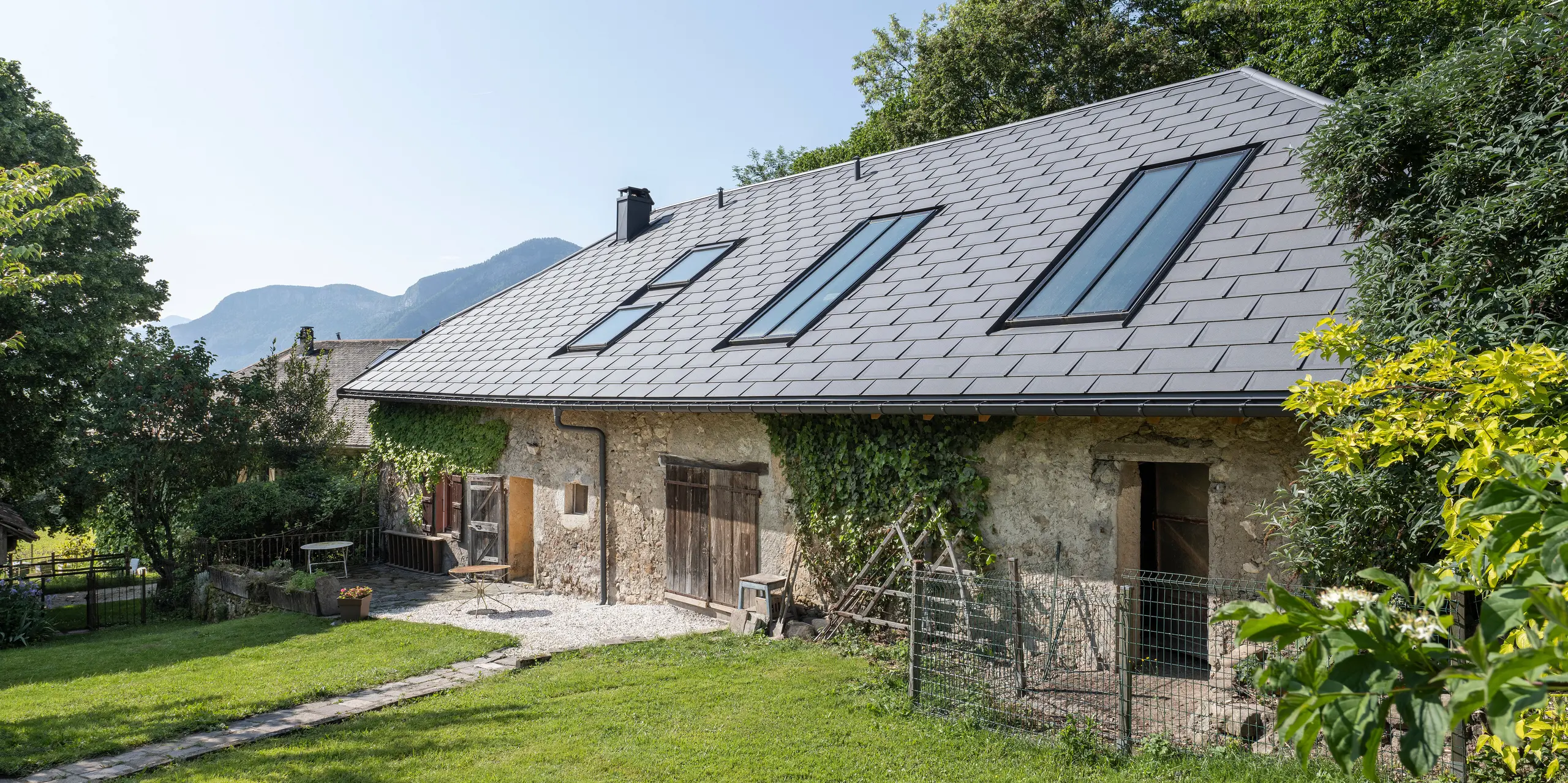 PREFA strešný panel R.16 v P.10 tmavošedej farbe na streche starej farmy v Héry-sur-Alby (Francúzsko)