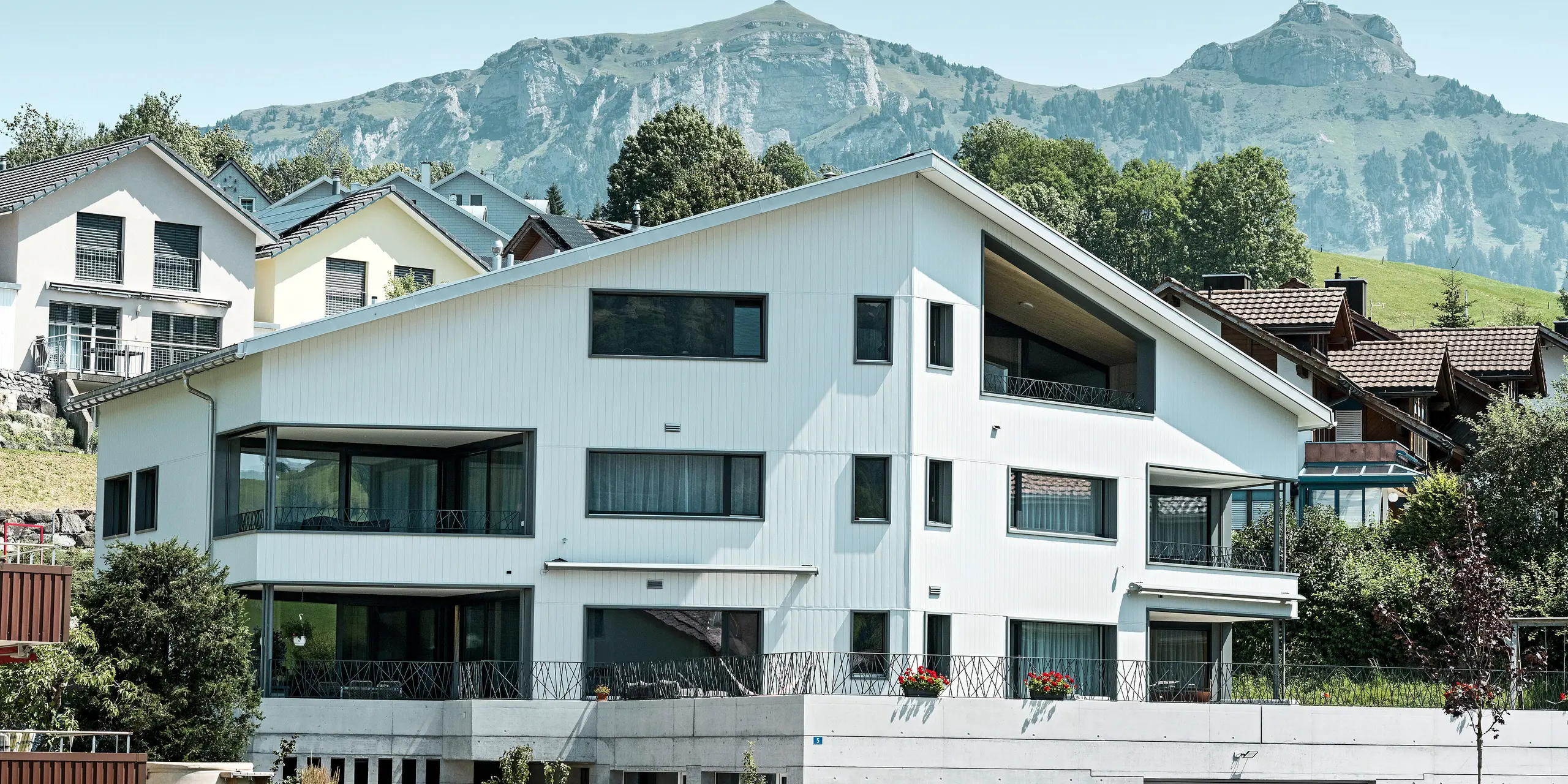 PREFA Siding vo farbe P.10 kamenná šedá a P.10 prefa biela na fasádach dvoch susedných bytových domov vo Weissbad vo Švajčiarsku.