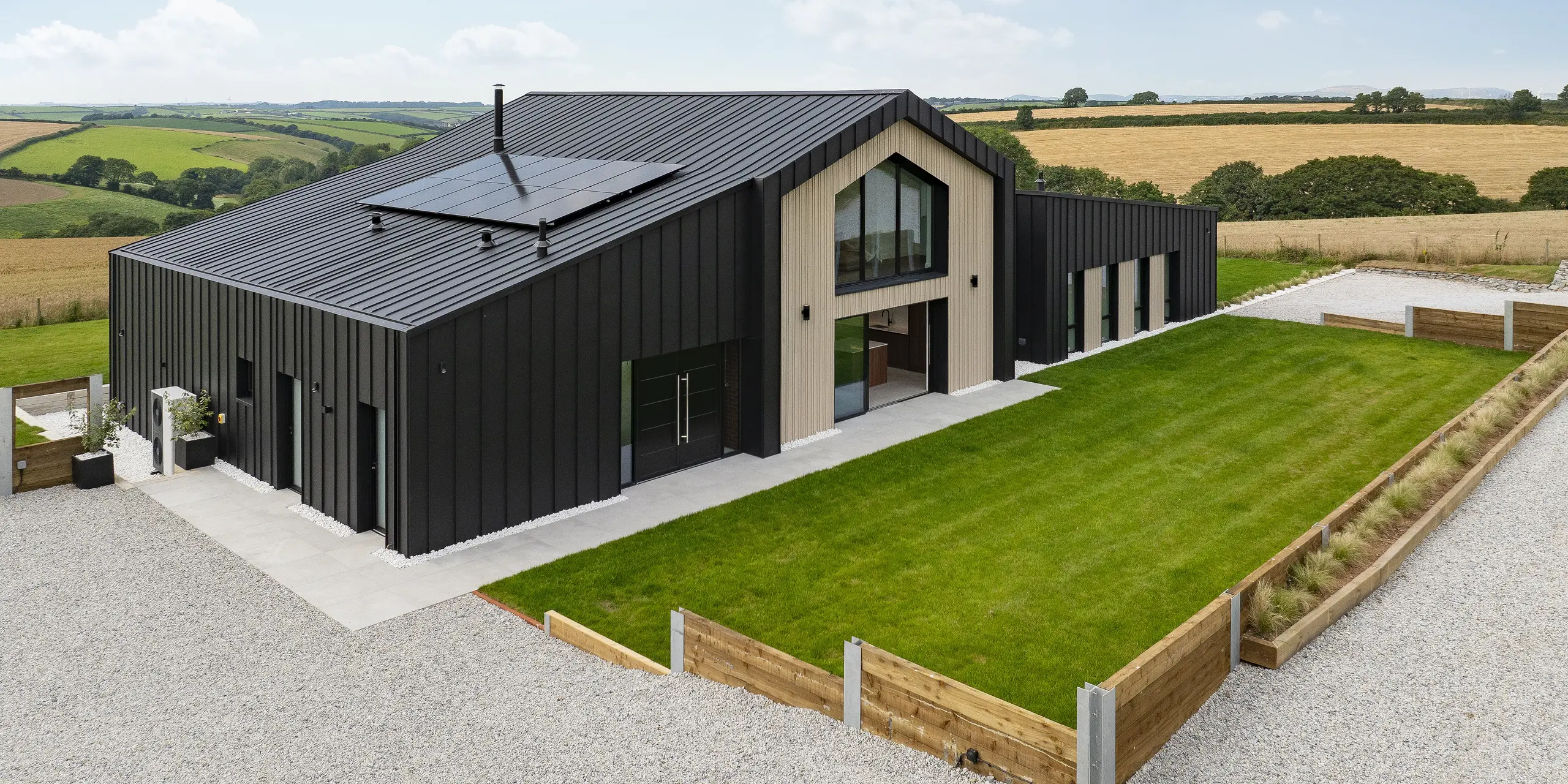 Das Einfamilienhaus „The Hide“ in Cornwall fügt sich mit seinem klaren Design und der eleganten PREFALZ Stehfalzdeckung perfekt in die idyllische Landschaft ein. Die anthrazitfarbenen Aluminiumoberflächen bilden einen markanten Kontrast zu den umliegenden Feldern und unterstreichen die moderne Architektur.