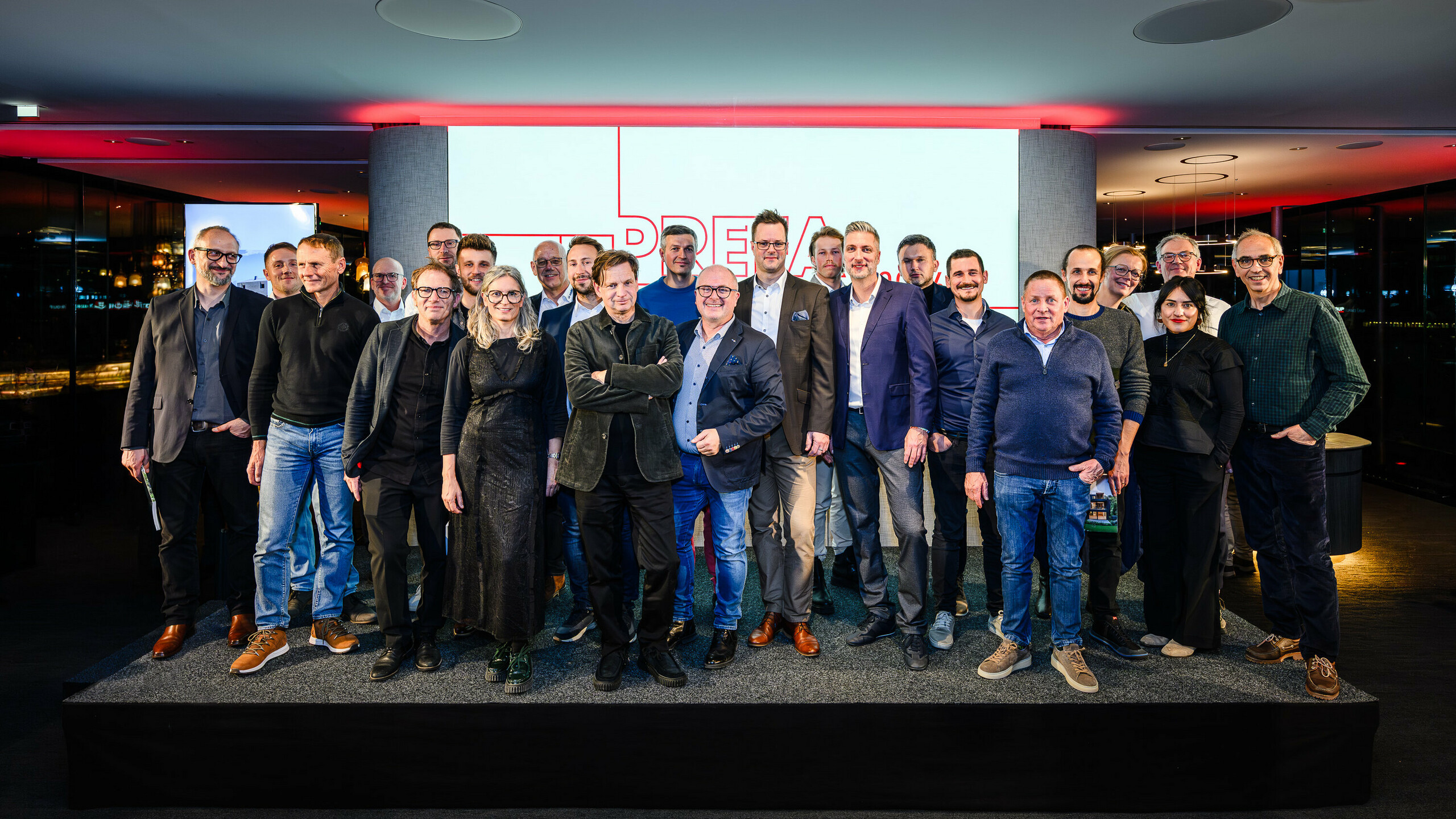 Skupinová fotografia architektov, projektantov a realizátorov na pódiu prezentácie PREFARENZEN 2026 v k47.wien – silný symbol spoločenstva, kreativity a architektúry orientovanej na budúcnosť. Pred svietiacim logom PREFARENZEN stoja dizajnéri, ktorí stoja za impozantnými projektmi s hliníkom PREFA. Scéna odráža hrdosť, inováciu a spoluprácu. Produkty PREFA ponúkajú trvácne, odolné voči poveternostným vplyvom riešenia s estetickými nárokmi – ideálne pre moderné architektonické koncepty. Inšpiratívny večer plný výmeny názorov, vízií a silných partnerstiev.