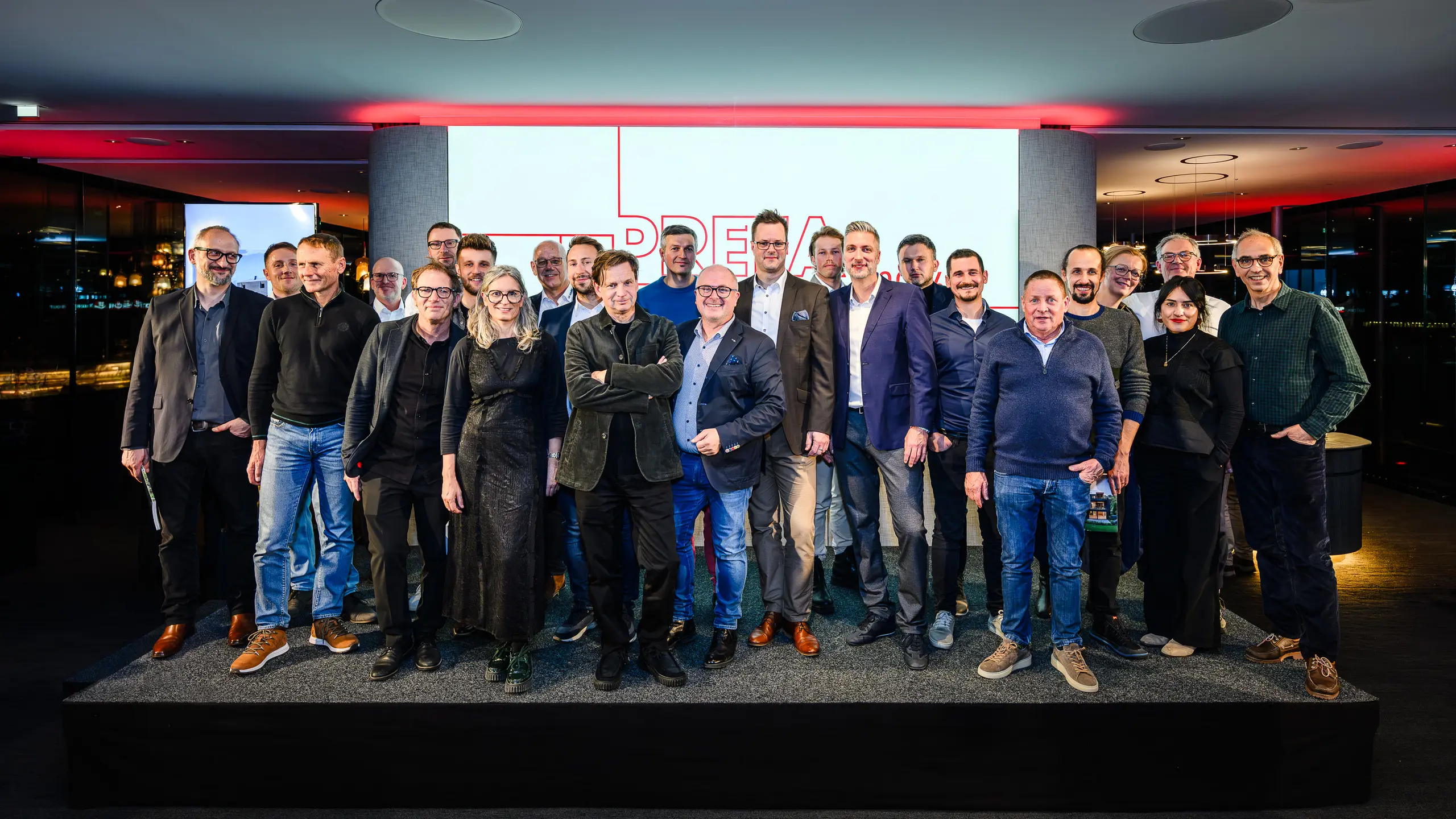Skupinová fotografia architektov, projektantov a realizátorov na pódiu prezentácie PREFARENZEN 2026 v k47.wien – silný symbol spoločenstva, kreativity a architektúry orientovanej na budúcnosť. Pred svietiacim logom PREFARENZEN stoja dizajnéri, ktorí stoja za impozantnými projektmi s hliníkom PREFA. Scéna odráža hrdosť, inováciu a spoluprácu. Produkty PREFA ponúkajú trvácne, odolné voči poveternostným vplyvom riešenia s estetickými nárokmi – ideálne pre moderné architektonické koncepty. Inšpiratívny večer plný výmeny názorov, vízií a silných partnerstiev.