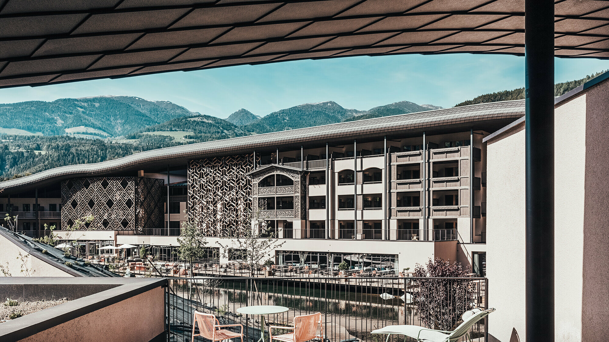 Ein Blick von der Terrasse auf das Falkensteinerhotel. Hügelige Berglandschaft ist im Hintergrund zu sehen.