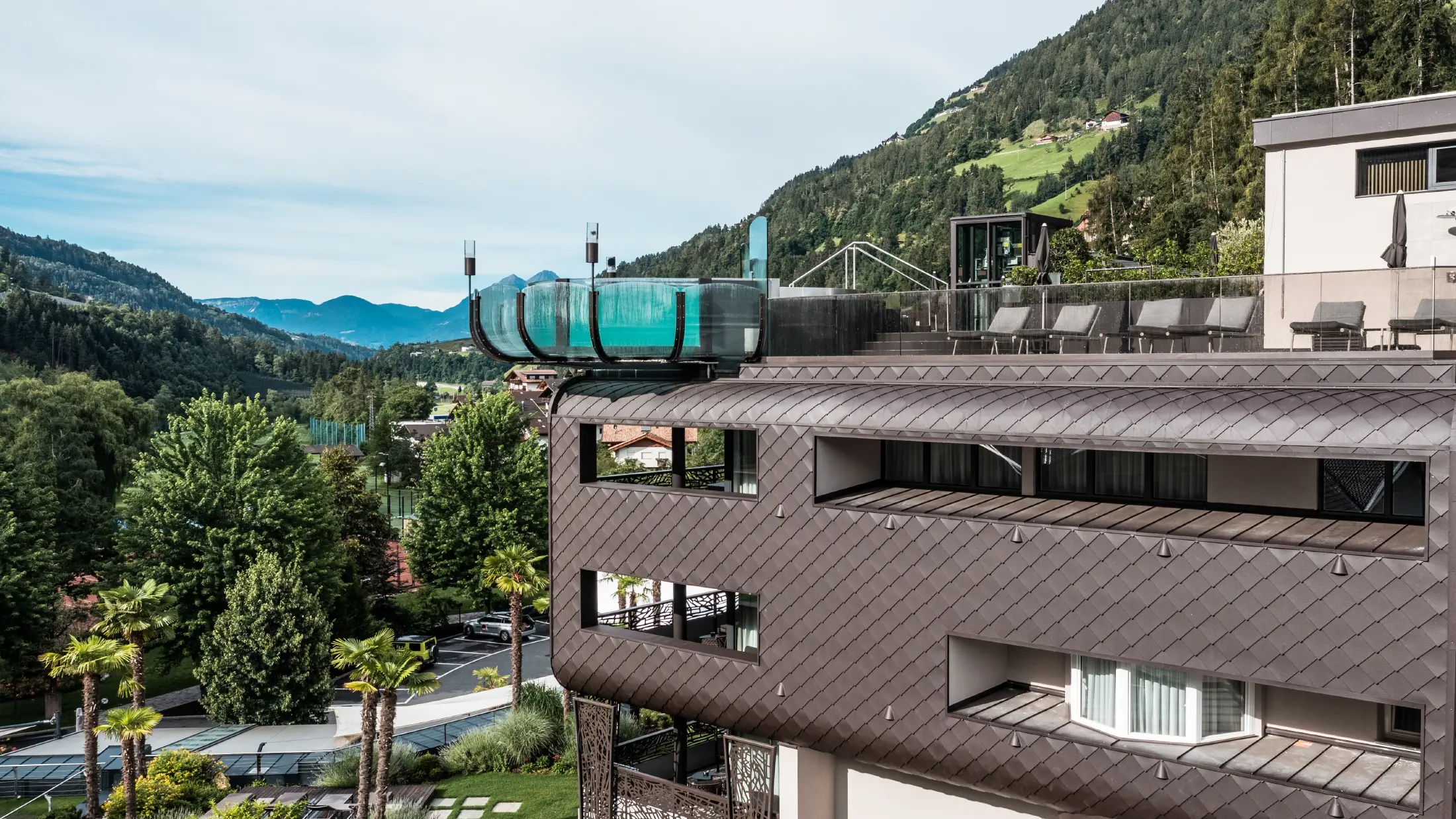 Neben den PREFA-Fassadenschindeln sticht der beeindruckende Pool des Hotelbereichs hervor.