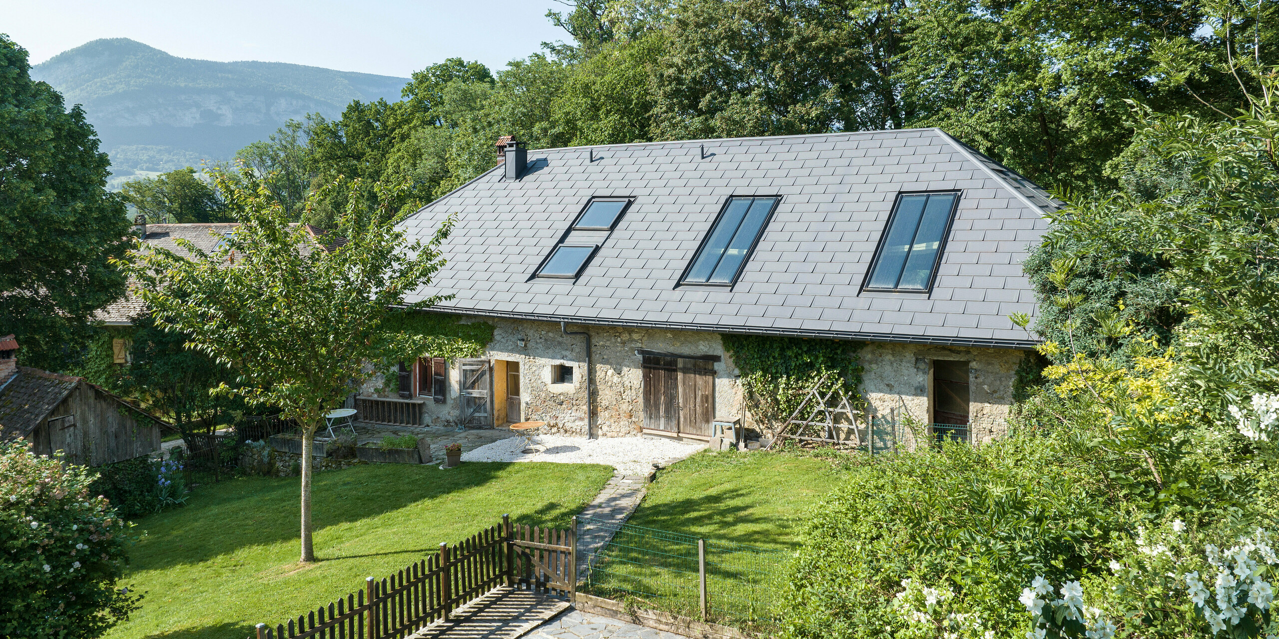 PREFA strešný panel R.16 v P.10 tmavošedej farbe na streche starej farmy v Héry-sur-Alby (Francúzsko)