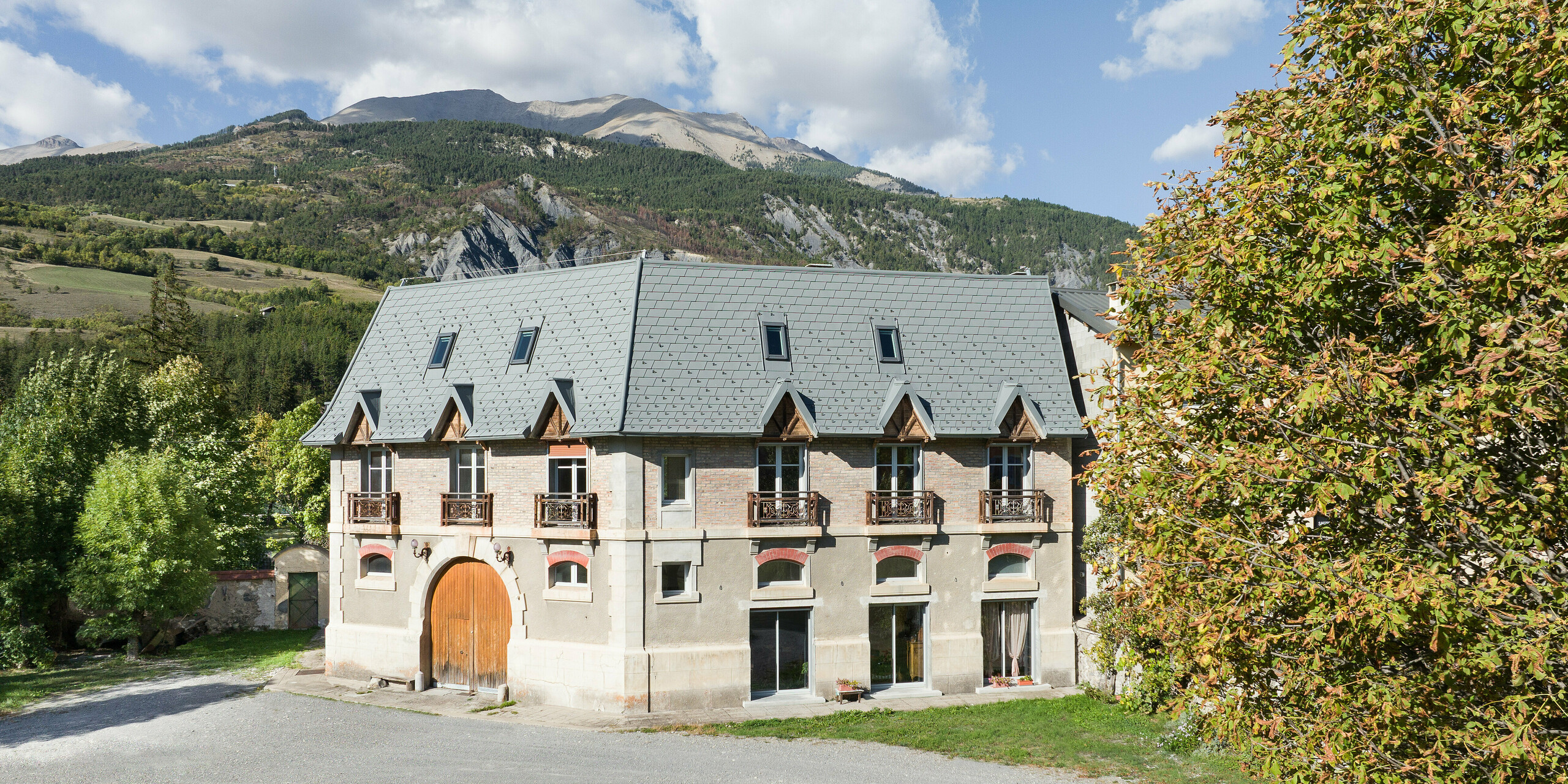 Pohľad spredu na nehnuteľnosť v Barcelonnette, Francúzsko. Extenzívna strecha bola renovovaná strešným šindľom PREFA vo farbe svetlošedá P.10.