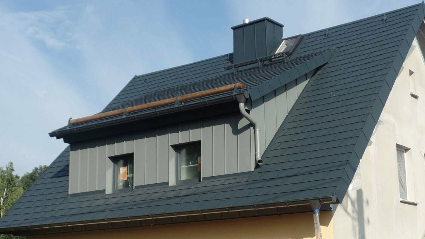 Objekt so sedlovou strechou a pultovým vikierom po rekonštrukcii s použitím PREFA falcovaných šindľov 