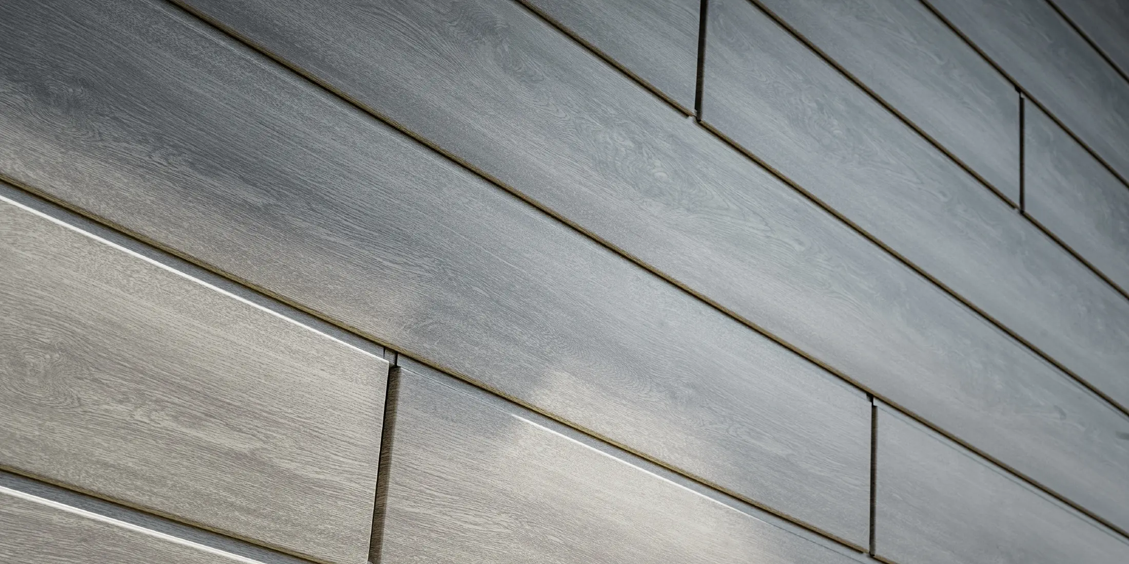 Detailný pohľad na hliníkovú fasádu PREFA Siding, hliníkové panely boli položené horizontálne a majú vzhľad dreva – dub béžovosivý.