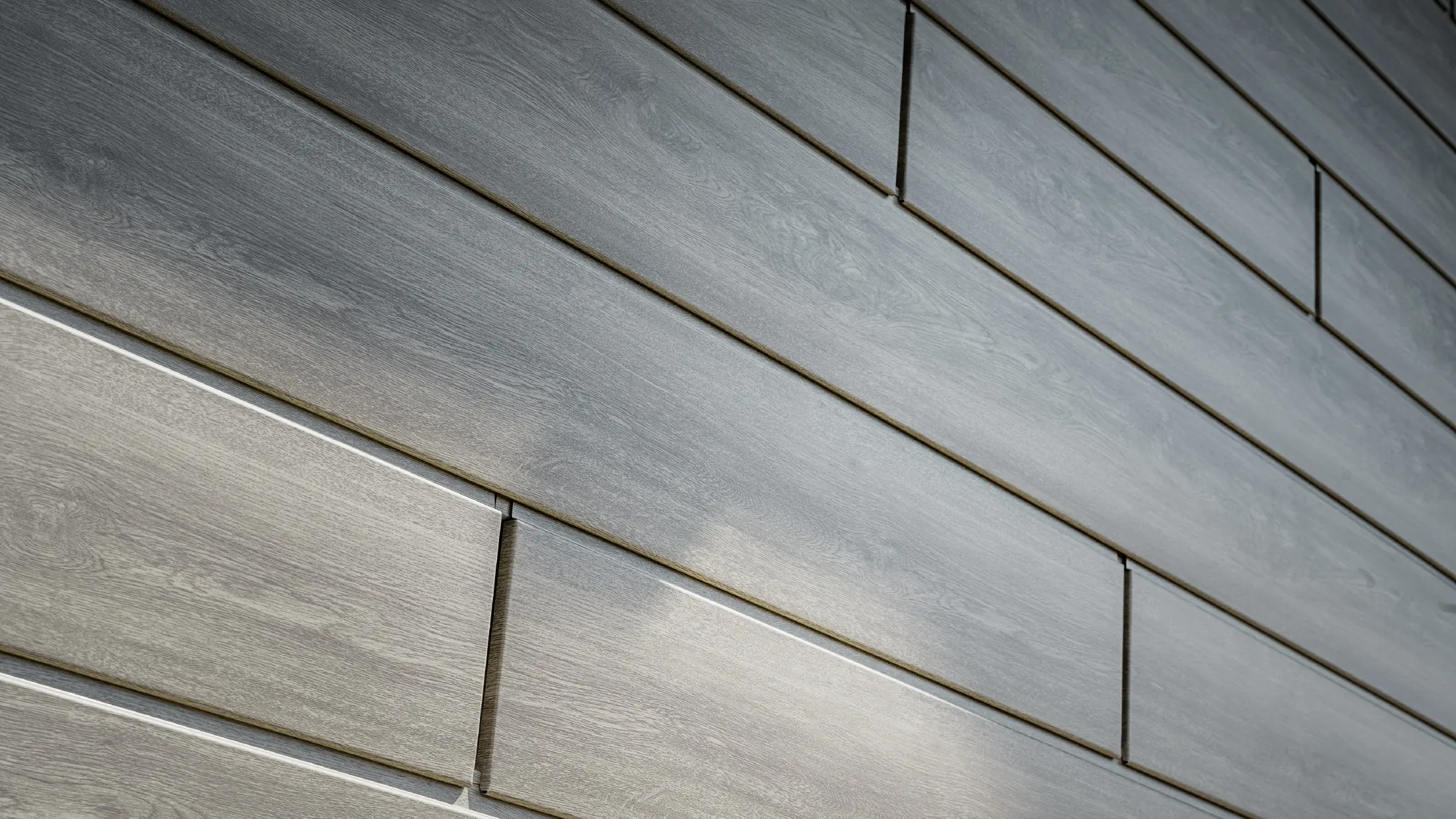 Detailný pohľad na hliníkovú fasádu PREFA Siding, hliníkové panely boli položené horizontálne a majú vzhľad dreva – dub béžovosivý.