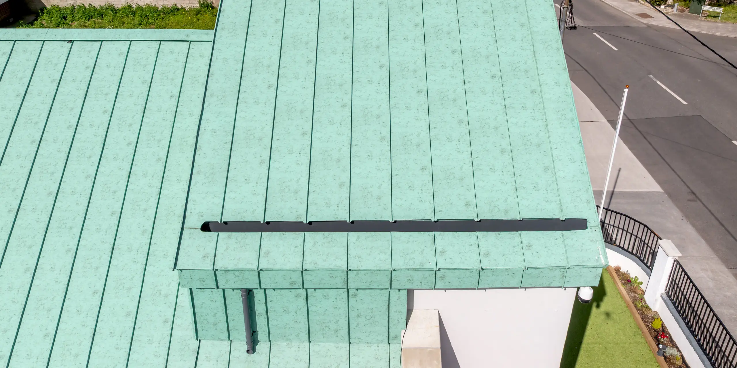Detailaufnahme des markanten PREFALZ Aluminium-Stehfalzdachs der St. Thomas Orthodox Church in Dublin. Die großzügigen Dachflächen in P.10 Patinagrün prägen das Erscheinungsbild des Sakralbaus und ziehen mit ihrer an historische Kupferdächer erinnernden Optik sofort die Aufmerksamkeit auf sich. Die präzisen Falzlinien betonen die klare Architektur und verleihen dem Dach eine elegante Struktur. Das hochwertige PREFA Aluminium überzeugt durch Langlebigkeit, Korrosionsbeständigkeit, geringes Gewicht und hohe Farbbeständigkeit – ideal für anspruchsvolle Architektur mit zeitloser Ausstrahlung.