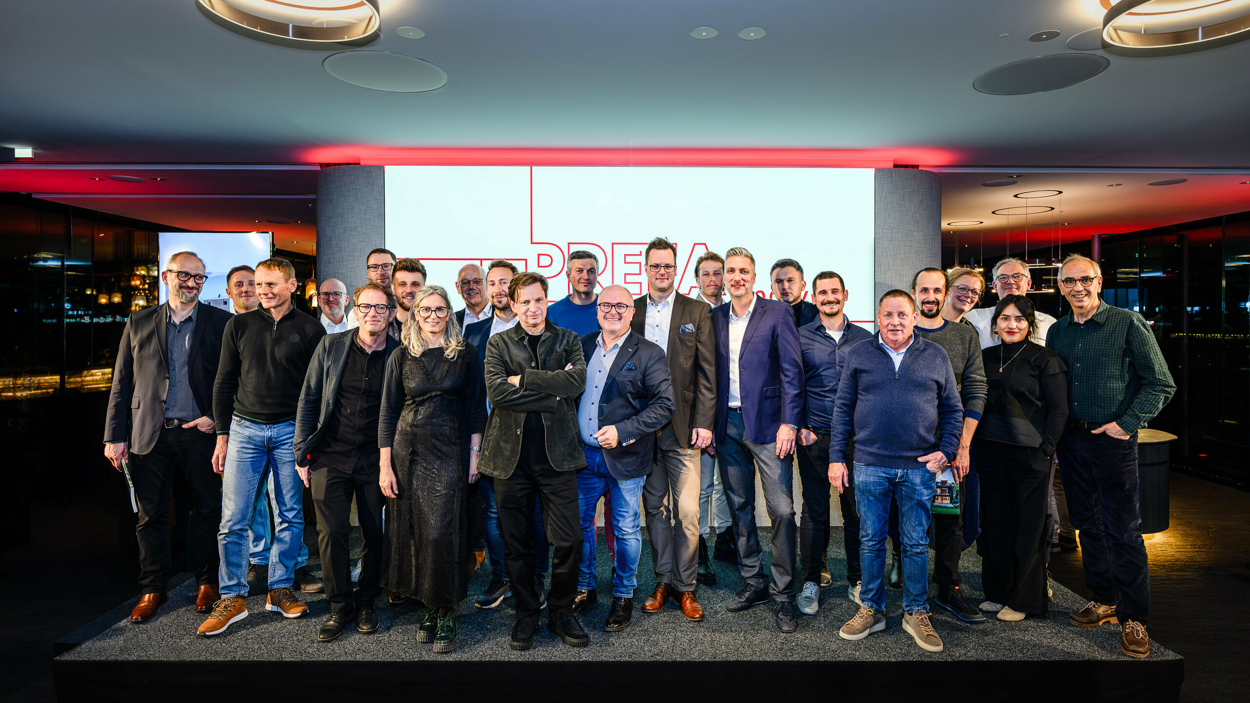 Skupinová fotografia architektov, projektantov a realizátorov na pódiu prezentácie PREFARENZEN 2026 v k47.wien – silný symbol spoločenstva, kreativity a architektúry orientovanej na budúcnosť. Pred svietiacim logom PREFARENZEN stoja dizajnéri, ktorí stoja za impozantnými projektmi s hliníkom PREFA. Scéna odráža hrdosť, inováciu a spoluprácu. Produkty PREFA ponúkajú trvácne, odolné voči poveternostným vplyvom riešenia s estetickými nárokmi – ideálne pre moderné architektonické koncepty. Inšpiratívny večer plný výmeny názorov, vízií a silných partnerstiev.