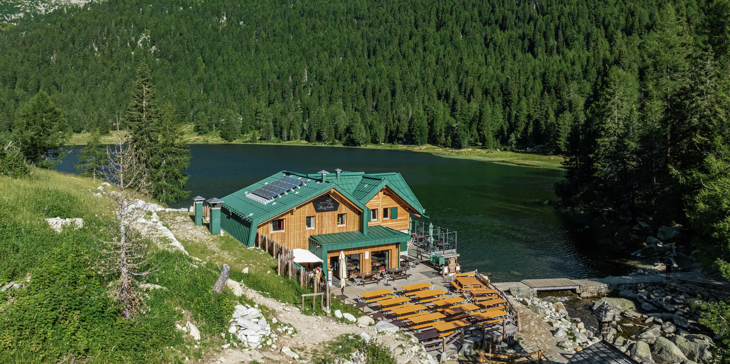 Rifugio Malghette v nadmorskej výške 1 888 m, idylicky situované pri jazere, so strechou PREFALZ vo farbe P.10 machovozelená - odolná voči poveternostným vplyvom a dokonale integrovaná do prírody. Priestranná slnečná terasa pozýva turistov na zotrvanie, zatiaľ čo odolná hliníková strecha odoláva aj extrémnemu horskému počasiu.