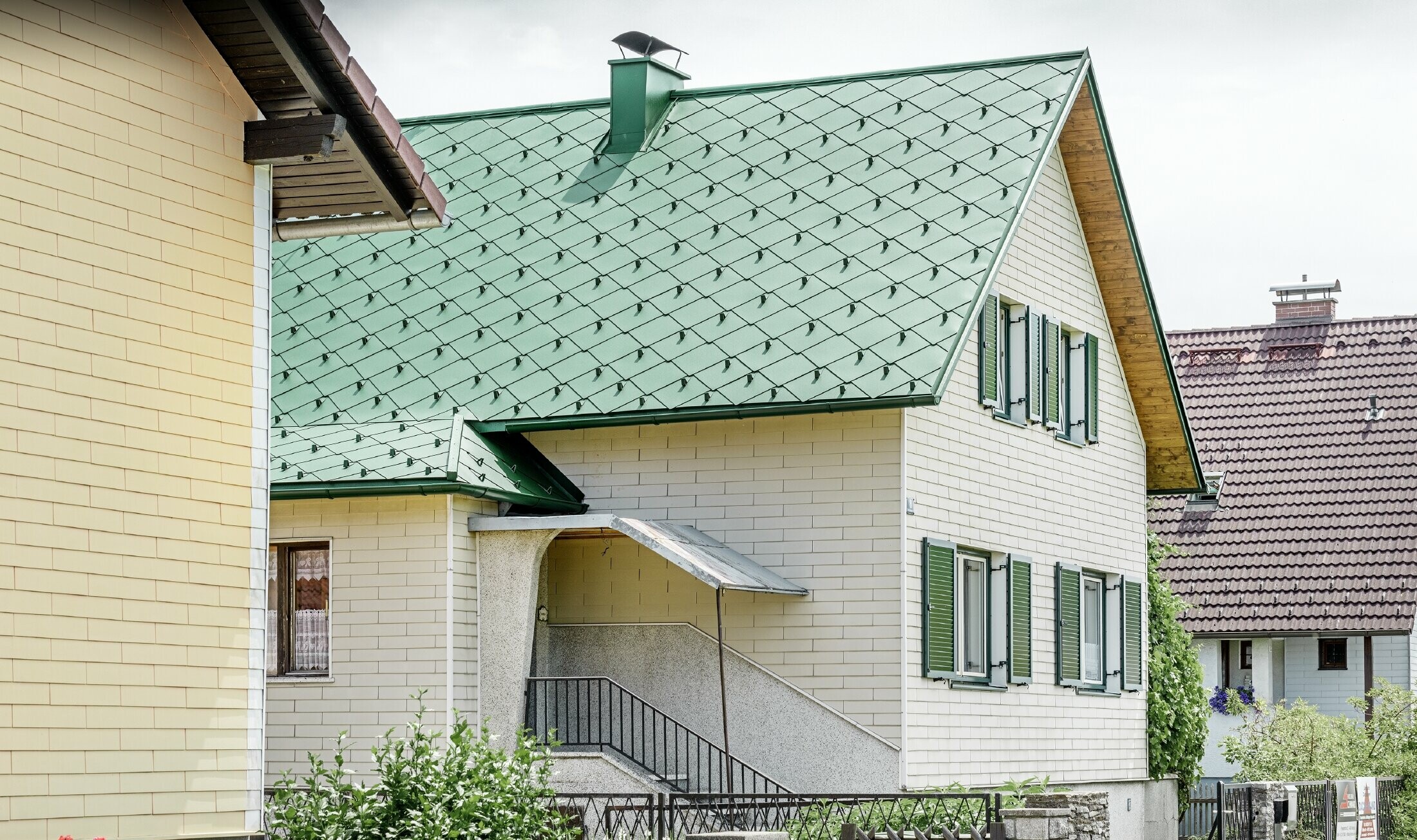 Klasický rodinný dom so sedlovou strechou z hliníka v machovozelenej farbe a zelenými okenicami