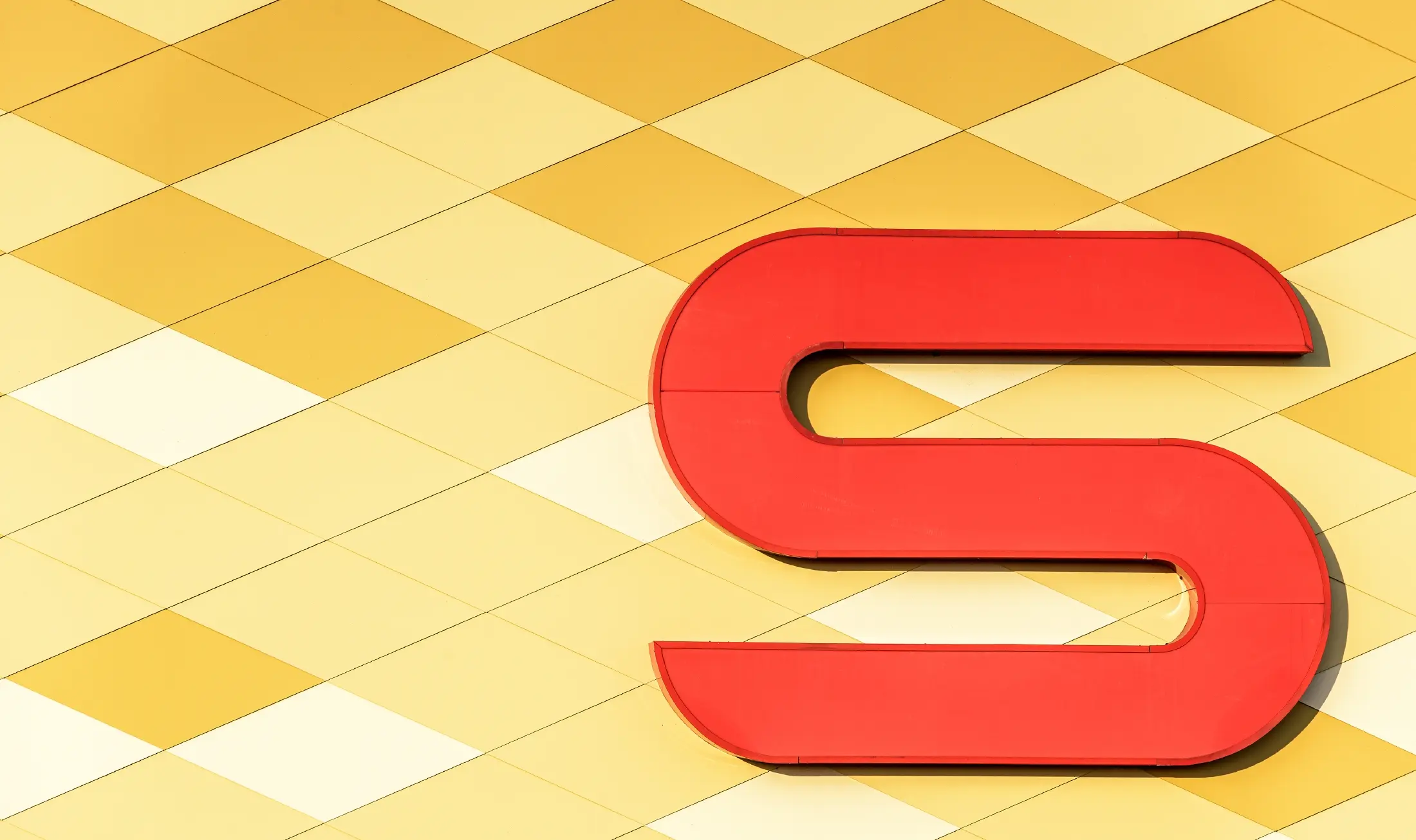 Predajňa obchodného reťazca Spar s hliníkovou fasádou v žltooranžovom károvanom dizajne s logom Spar