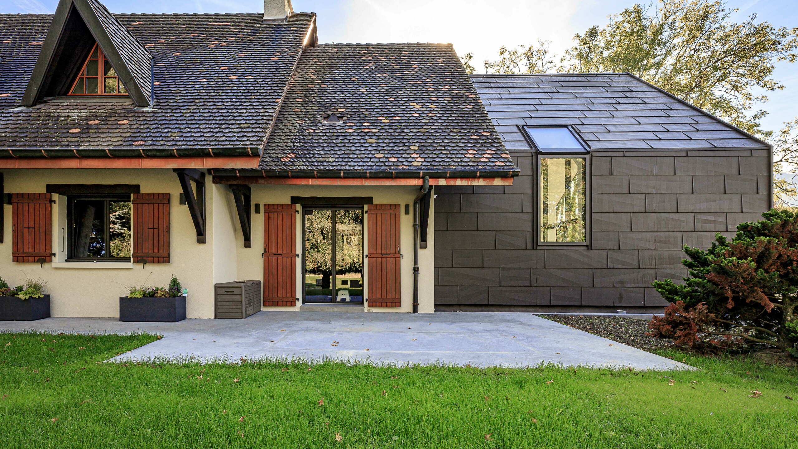 PREFA strešné a fasádne panely FX.12 v hnedej P.10 ako vysoko kontrastný dizajnový prvok na prístavbe rodinného domu v Lully