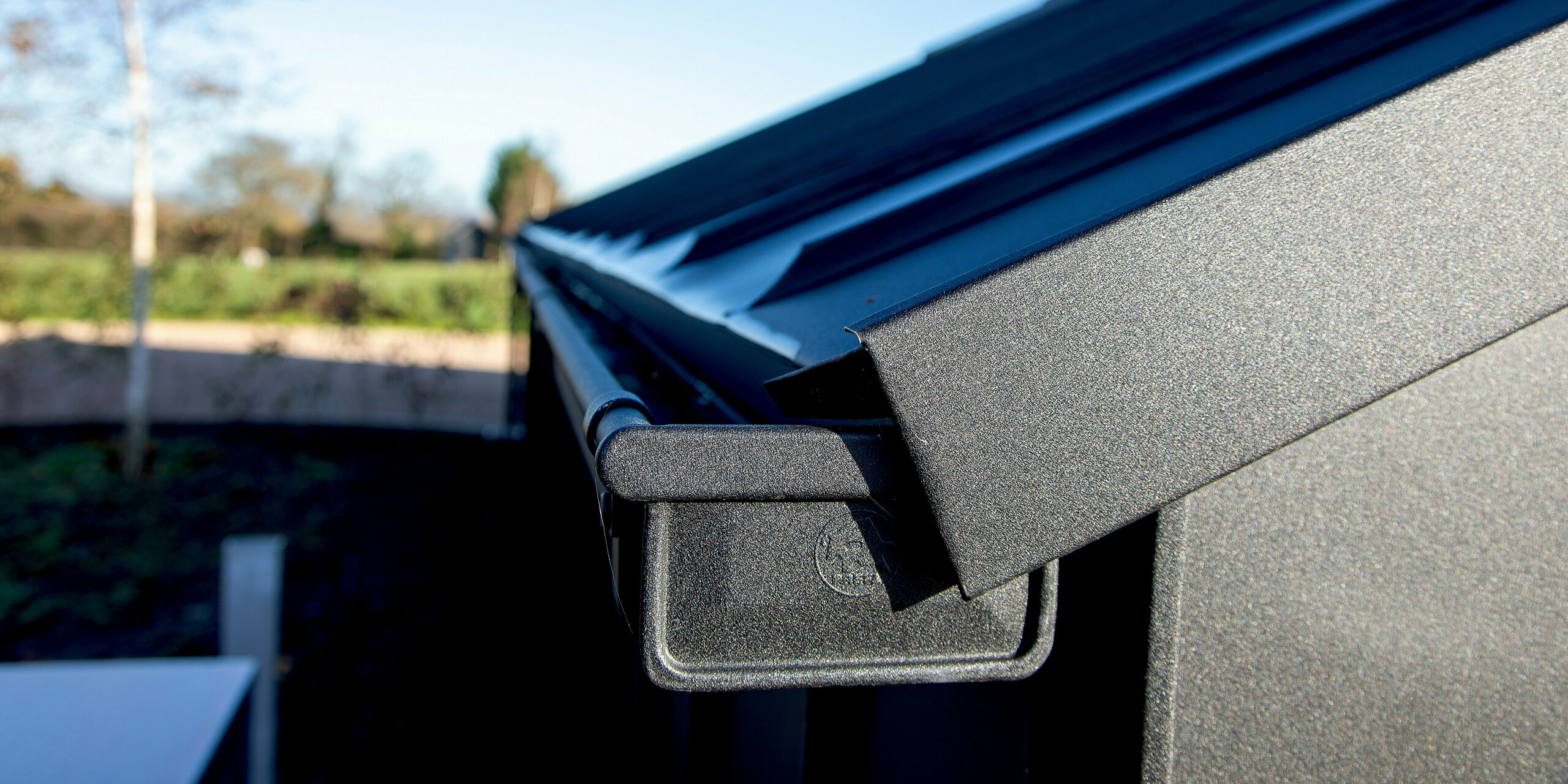 Detailaufnahme einer modernen PREFA Dachkonstruktion mit PREFALZ in P.10 Schwarz. Die präzise ausgeführte Aluminium-Kastenrinne und die robuste Dachverkleidung erzeugen klare Linien und eine hochwertige Optik. Die langlebige, witterungsbeständige Aluminiumoberfläche sorgt für maximale Stabilität und ein markantes architektonisches Erscheinungsbild im Außenbereich.