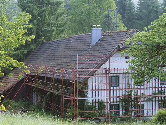 stará strecha na budove Wiesenhaus krátko pred renováciou strechy so strešným šindľom PREFA, s lešením