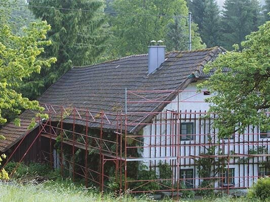 stará strecha na budove Wiesenhaus krátko pred renováciou strechy so strešným šindľom PREFA, s lešením