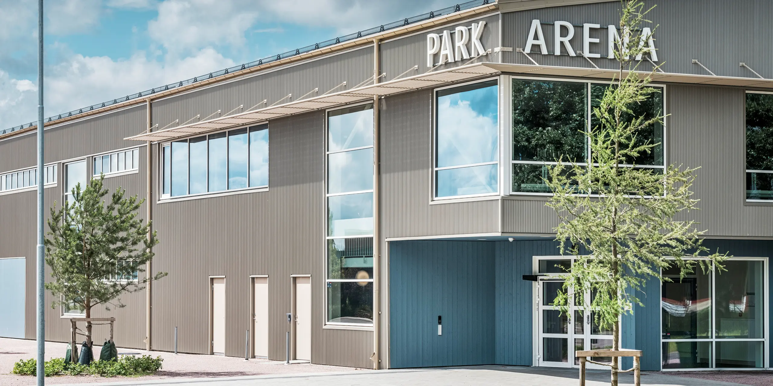 Vstupná časť Park Areny vo švédskom meste Värnamo s moderným dizajnom fasády v podobe prelamovaného profilu PREFA v bronzovej farbe. Trvanlivá hliníková fasáda odolná voči poveternostným vplyvom dodáva športovej hale s rozlohou 3 300 m² elegantný a výrazný vzhľad. Prelamovaný profil PREFA vytvára fascinujúce svetelné a tieňové efekty, ktoré zdôrazňujú architektonický dizajn arény.