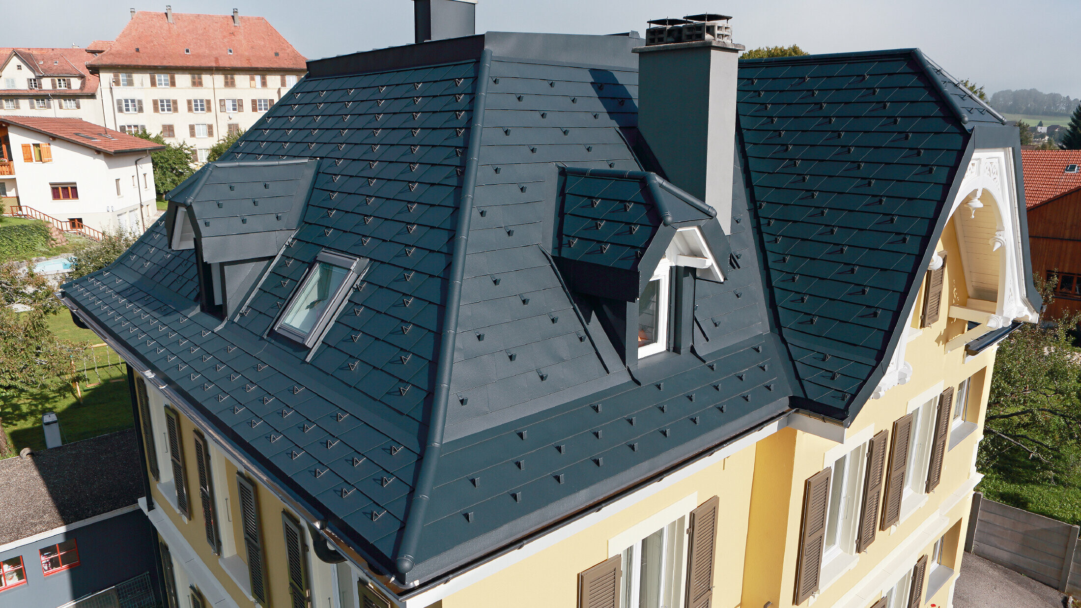 Vila vo Švajčiarsku, strecha s mnohými úžľabiami a bez vikierov, strecha je pokrytá hliníkovým šindľom od spoločnosti PREFA vo farbe P.10 antracitová