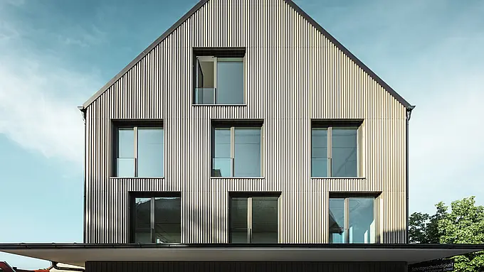 Na obrázku je zobrazená moderná budova s fasádnym obkladom z materiálu Prefalz vo farbe bronzová a šikmou strechou, ktorá je tiež pokrytá materiálom Prefalz v čiernošedej farbe. Veľká sklenená fasáda na prízemí je orámovaná stromami a vytvára príjemnú atmosféru pre reštauračné priestory pod ňou. Kombinácia kvalitných materiálov Prefalz a modernej architektúry dodáva budove elegantný a súčasný vzhľad.