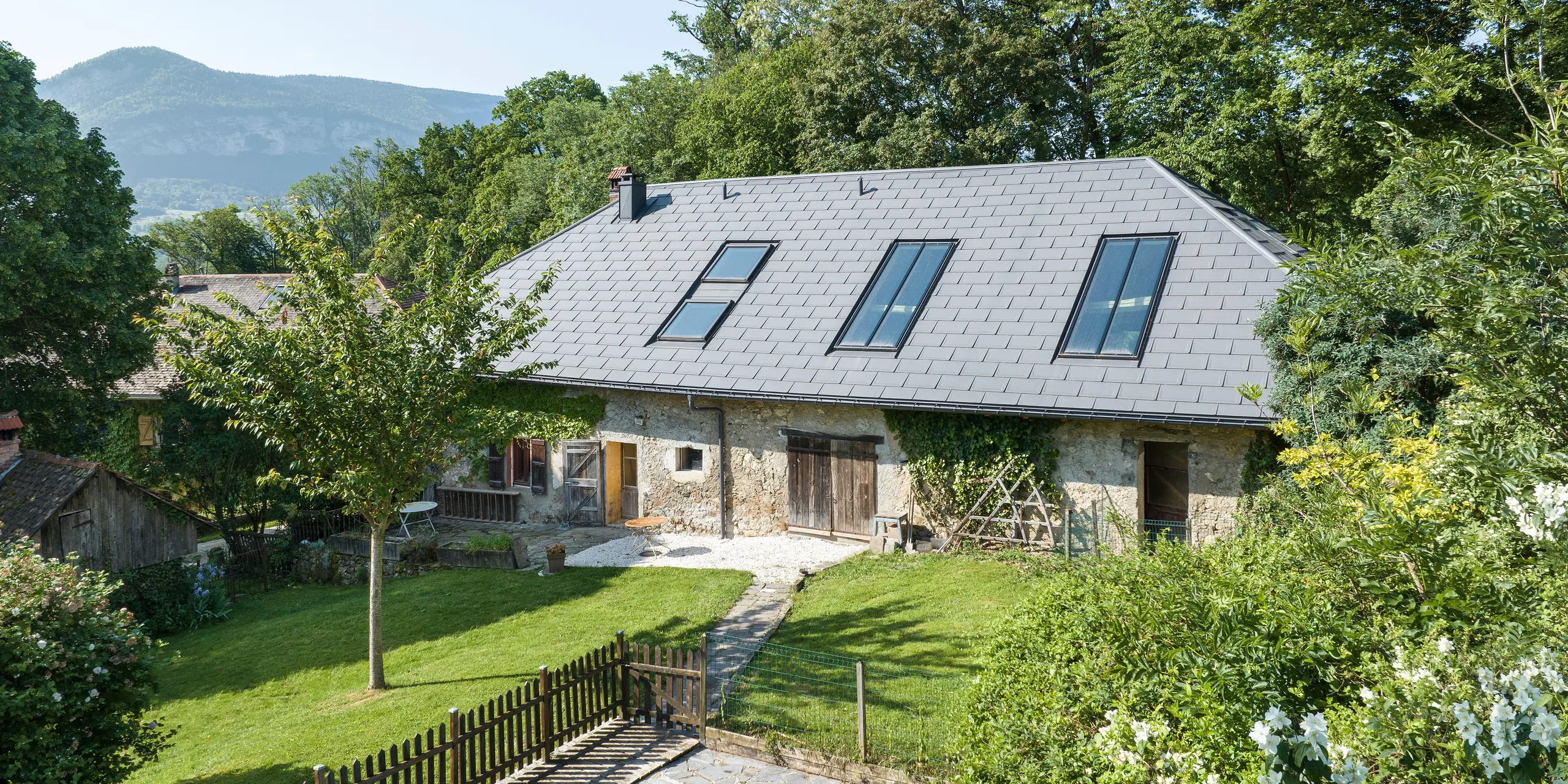 PREFA strešný panel R.16 v P.10 tmavošedej farbe na streche starej farmy v Héry-sur-Alby (Francúzsko)