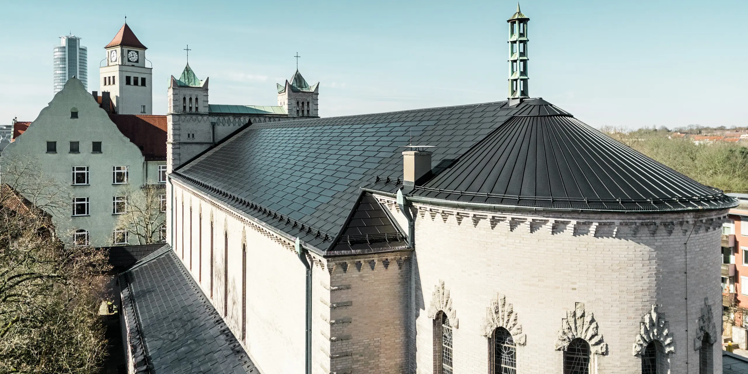 Rekonštrukcia Kostola svätého Karola Boromejského v Norimbergu je pôsobivým príkladom toho, ako možno moderné integrované solárne panely PREFA harmonicky integrovať do pamiatkovo chránenej budovy. Čierne solárne panely na streche umožňujú efektívnu a ekologickú výrobu energie. Prístavby kostola boli pokryté strešnými panelmi PREFA R.16. Pôsobivý oblúk v zadnej časti budovy bol pokrytý hliníkovou strešnou krytinou Prefalz.