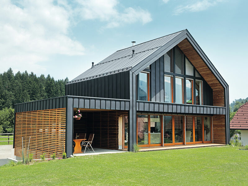 Obytný dom s flexibilnou a odolnou hliníkovou strechou PREFA a fasádnym obkladom v antracitovej farbe.