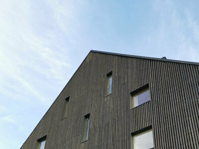 Celkový pohľad na drevenú fasádu s oplechovaním ostení okien Prefalz.