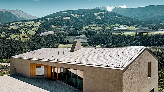 Vzdelávacie centrum Riffian v Južnom Tirolsku predstavuje modernú architektúru so strešnými šablónami PREFA 44 × 44 v odtieni P.10 bronzová. Odolná hliníková strecha harmonicky zapadá do horskej krajiny, vyniká precíznym spracovaním a poskytuje materskej aj základnej škole dlhodobú ochranu pred poveternostnými vplyvmi.