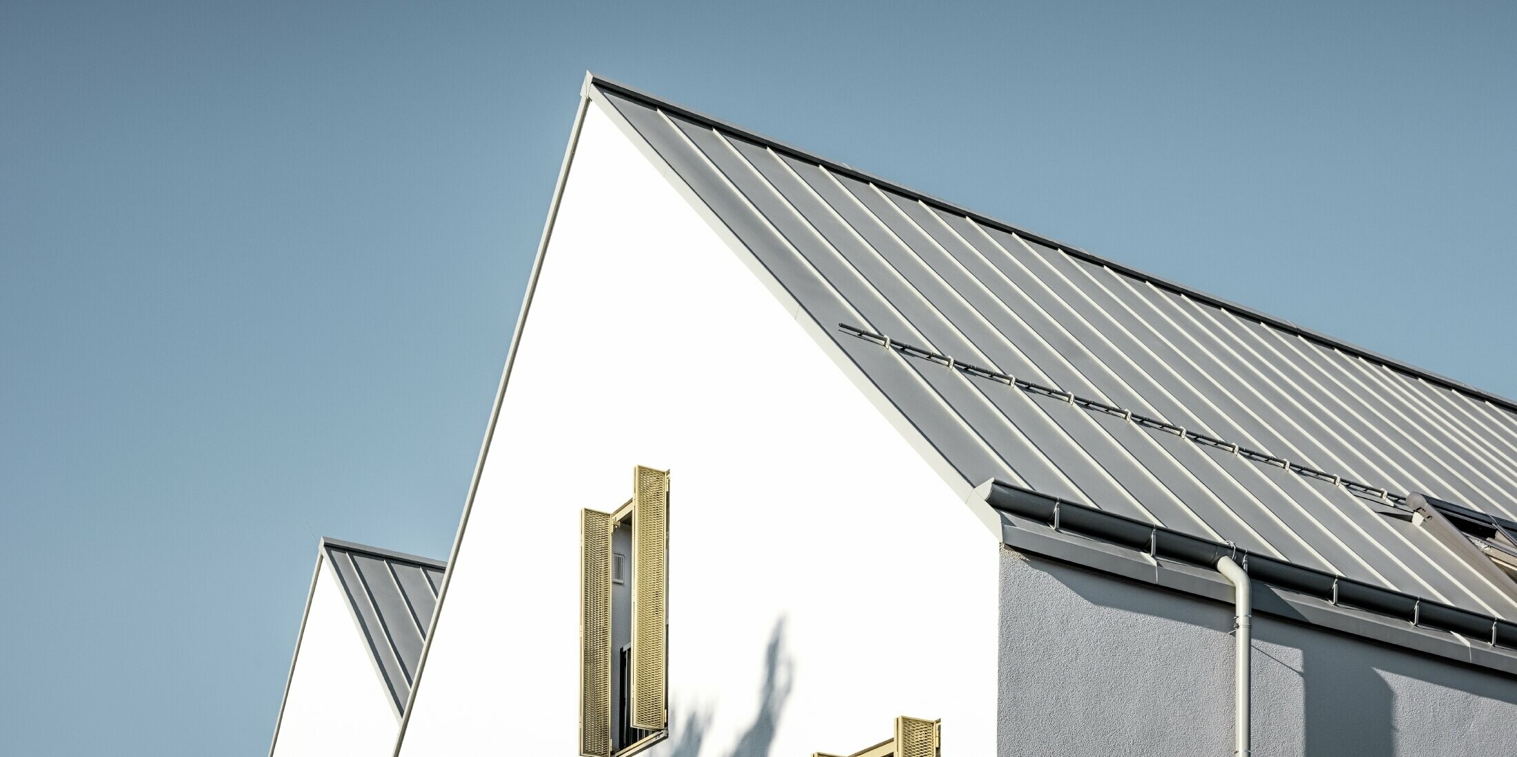 Sedlová strecha bez previsnutej strechy, zakrytá s PREFALZ vo farebnom vyhotovení P.10 zinkovošedá s PREFA nástrešným žľabom