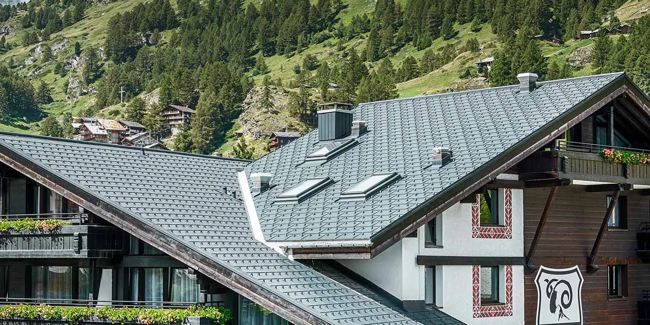 Hotel Alpenhof v Zermatte v pozadí s Matterhornom, balkóny, fasáda z tmavého dreva a hliníková strecha PREFA v antracitovej farbe