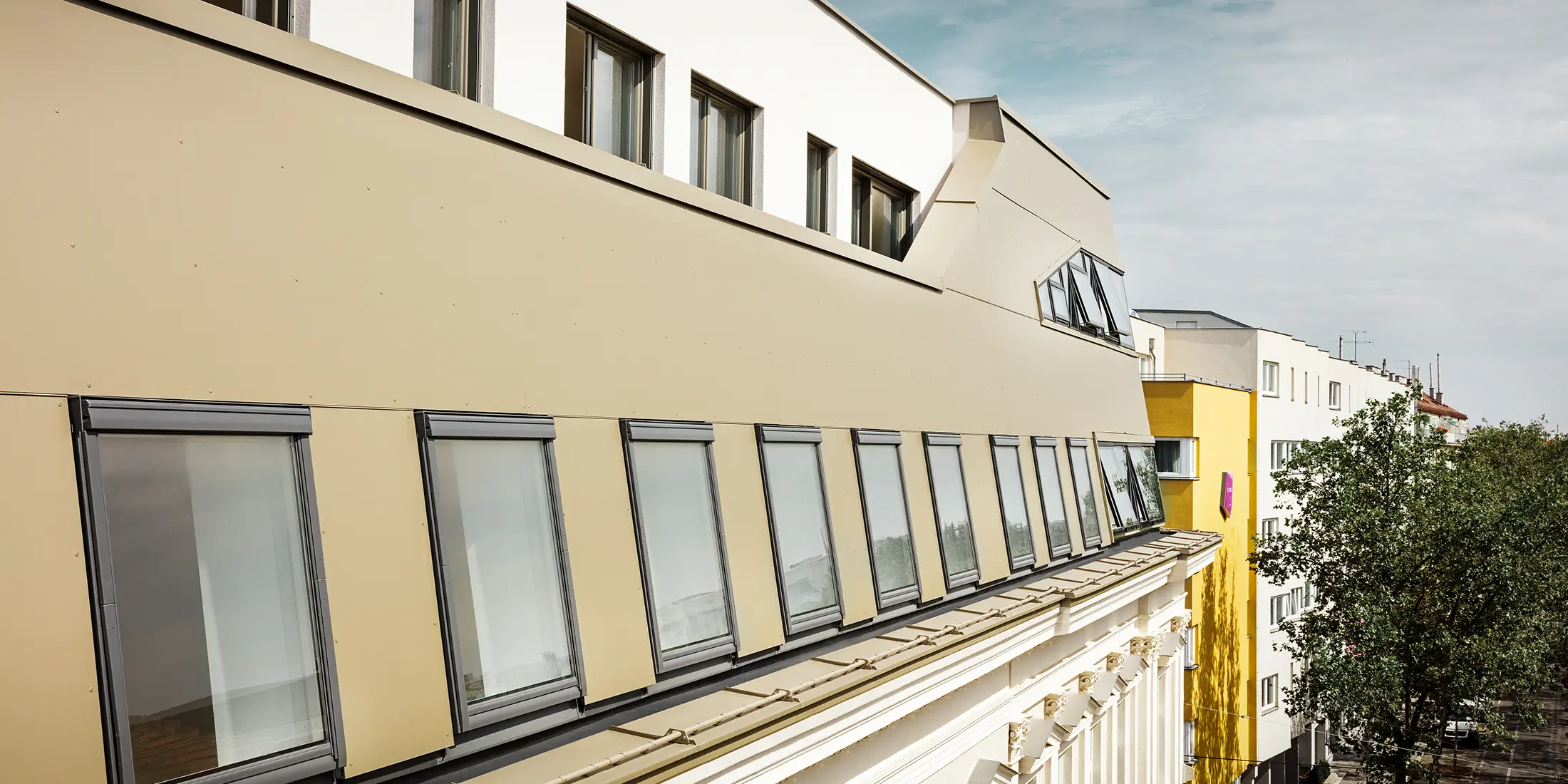 Vybudovanie strešnej nadstavby na Schloßhofer Straße vo Viedni s hliníkovým kompozitným panelom PREFA v bronzovej farbe