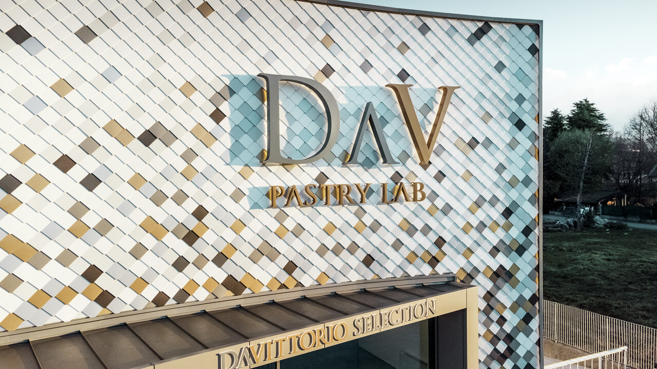 Firemné budovy z DAV Pastry Lab v Bergame s bodkovanou fasádou z fasádnych šablón vo farbách P.10 hnedá, bronzová, P.10 tmavošedá, majská zlatá, prírodný hliník, P.10 prefa biela a P.10 čistá biela 