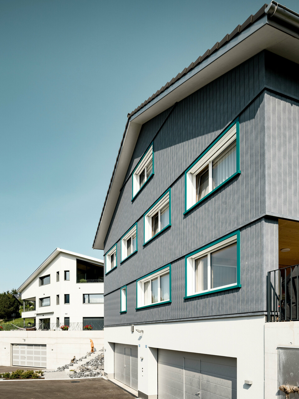 PREFA Siding vo farbe P.10 kamenná šedá a P.10 prefa biela na fasádach dvoch susedných bytových domov vo Weissbad vo Švajčiarsku.