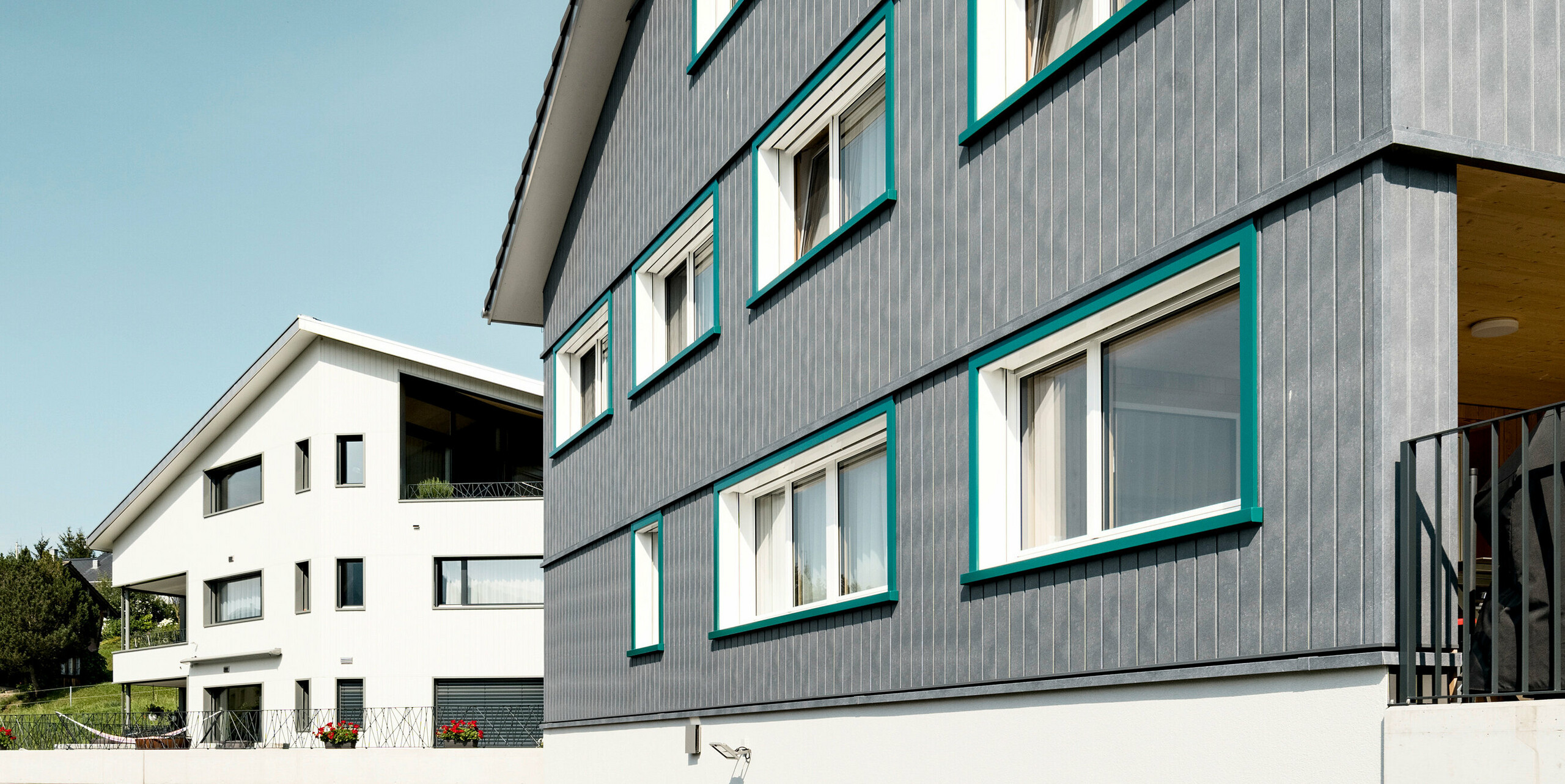 PREFA Siding vo farbe P.10 kamenná šedá a P.10 prefa biela na fasádach dvoch susedných bytových domov vo Weissbad vo Švajčiarsku.