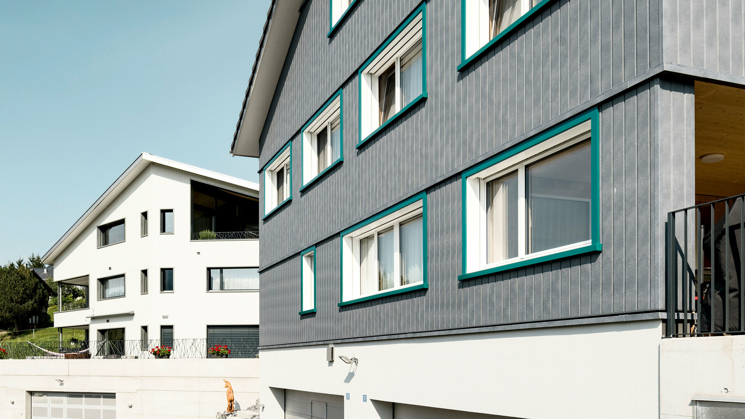 PREFA Siding vo farbe P.10 kamenná šedá a P.10 prefa biela na fasádach dvoch susedných bytových domov vo Weissbad vo Švajčiarsku.