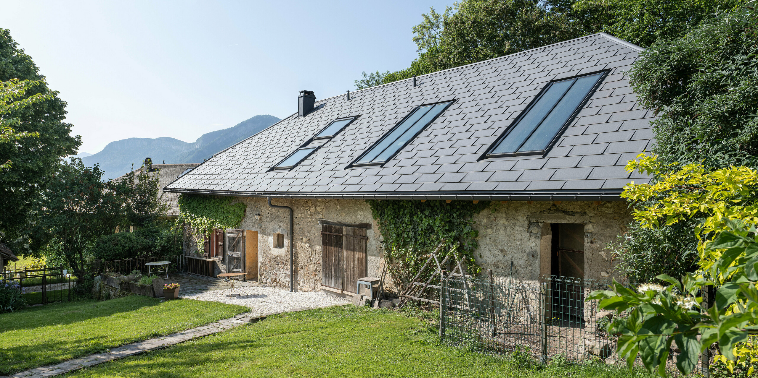 PREFA strešný panel R.16 v P.10 tmavošedej farbe na streche starej farmy v Héry-sur-Alby (Francúzsko)