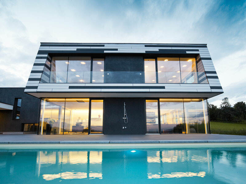 Rodinný dom s viacfarebnou fasádou s fasádnymi panelmi PREFA v matnej antracitovej a striebornej farbe vrátane tieňovej medzery.