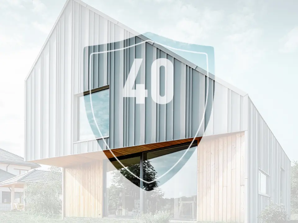 Na obrázku je pred moderným rodinným domom umiestnená tabuľa s číslom „40“, ktorá má predstavovať záruku na hliníkové výrobky PREFA.