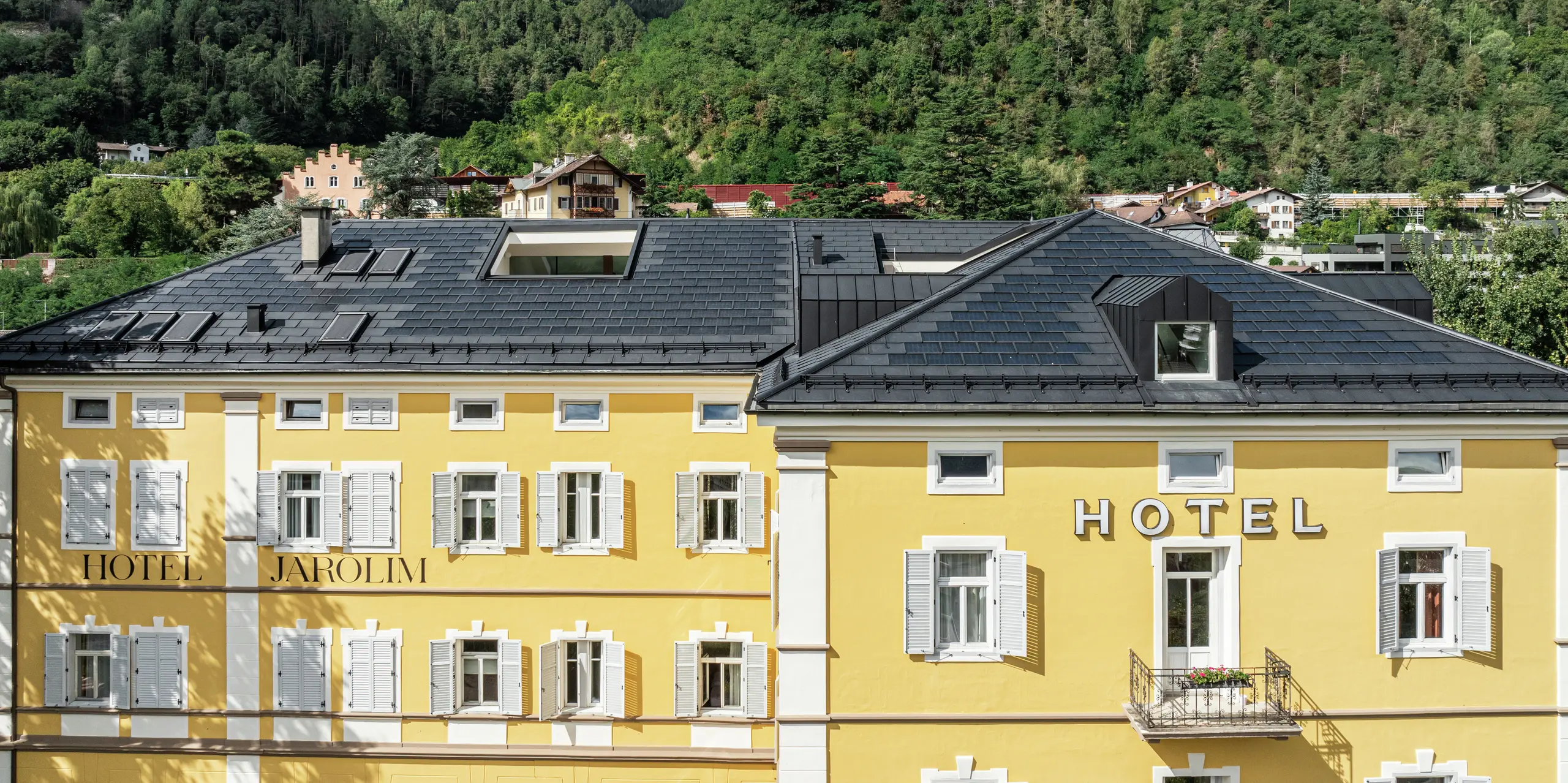 Hotel Jarolim v Brixene predstavuje svoju novú strechu z integrovaných solárnych panelov PREFA a strešných panelov R.16 v nadčasovej čiernej farbe P.10. Strešné riešenie spája robustnosť, odolnosť voči poveternostným vplyvom a ľahkosť, čo je ideálne pre pamiatkovo chránené budovy. Integrované fotovoltické moduly vyrábajú ekologickú elektrinu bez toho, aby narušili historický vzhľad. Presne padnúce vikiery a strešné detaily podčiarkujú vysokú kvalitu spracovania a estetickú univerzálnosť hliníkových produktov PREFA.
