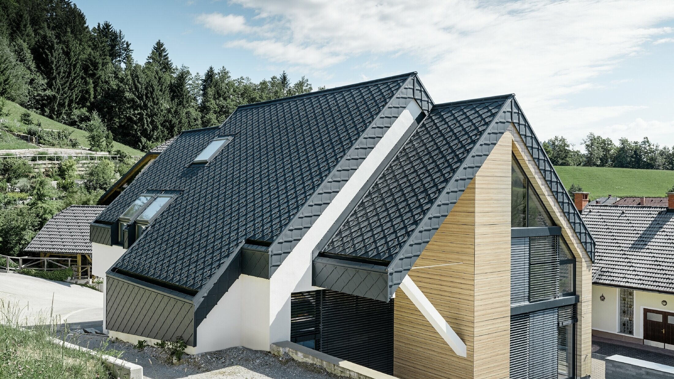 Rodinný dom s hliníkovou sedlovou strechou antracitovej farby bez previsu a s fasádou v drevenom vzhľade