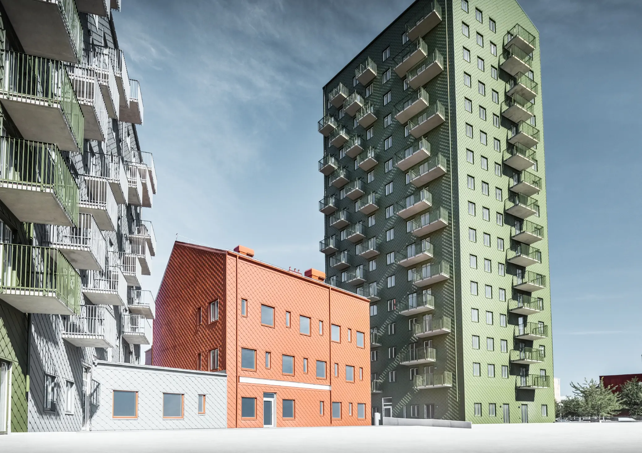 Mehrere Wohnbauten verkleidet mit der PREFA Wandraute 29 × 29 in den Farben Olivgrün, Ziegelrot und Hellgrau in Göteborg, Schweden.