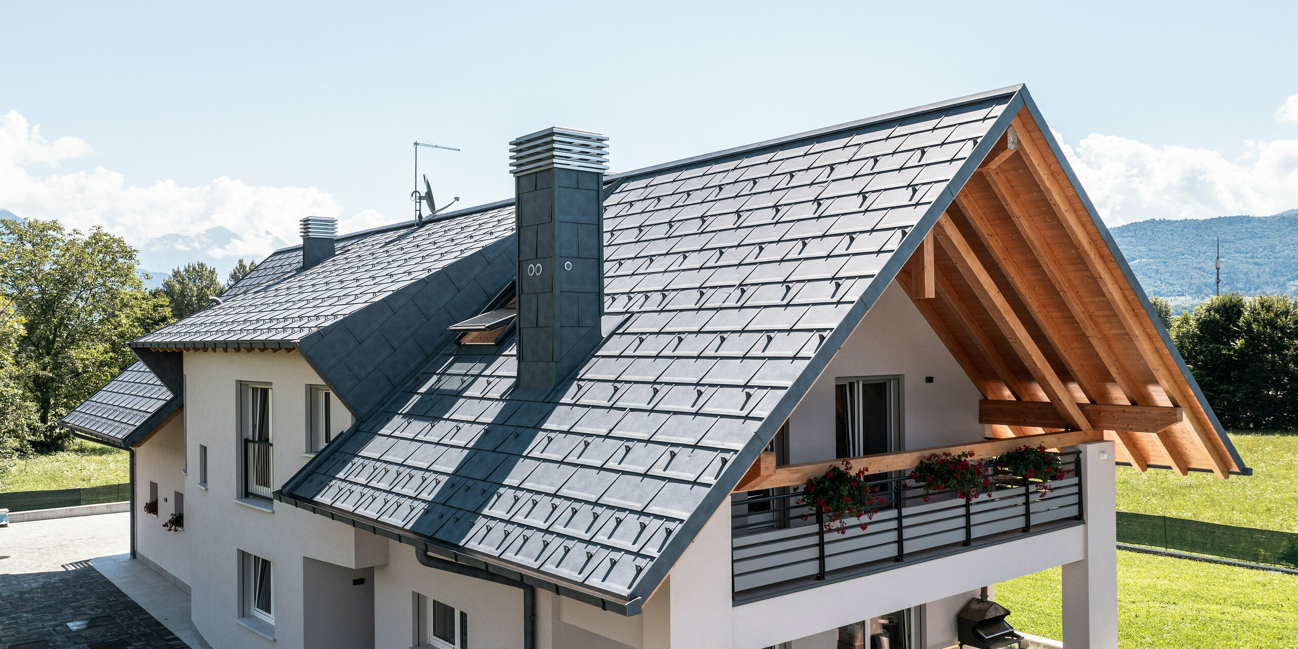 Tento malebný rodinný dom v Bellune je pokrytý strešnými panelmi PREFA R.16 v antracitovej farbe P.10, ktoré ponúkajú štýl aj funkčnosť. Kombinácia modernej hliníkovej strechy a tradičných drevených prvkov pod strechou vytvára atraktívny celkový obraz, ktorý dokonale zapadá do prírodného prostredia a horského pozadia Talianska.